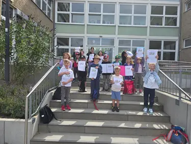 Die Kinder der Zwergenschule mit ihren Zeugnissen auf der Teppe der Schule
